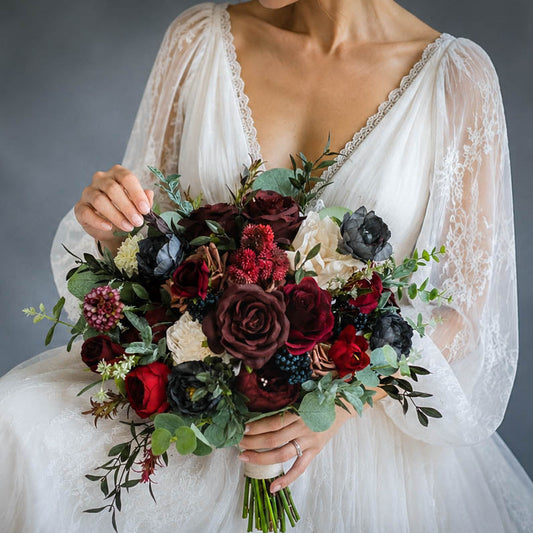 Bride holding a burgundy silk wedding bouquet with deep red, ivory, blush flowers and soft greenery